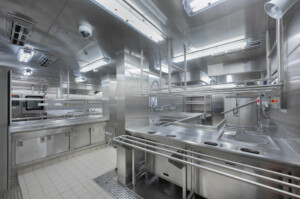 Modern industrial kitchen with stainless steel workstations, sinks, ventilation units, and hygienic modular layout—designed for marine catering, offshore galley systems, and professional food preparation by ALMACO.