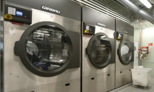 GIRBAU industrial washing machines in a clean marine laundry facility – part of ALMACO’s turnkey laundry solutions for cruise ships, offshore platforms, and marine accommodation.