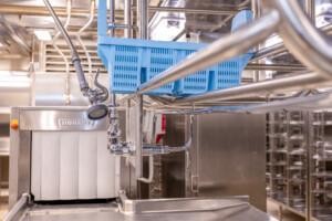 ALMACO commercial dishwashing station featuring Hobart dishwasher, stainless steel fixtures, and pre-rinse spray nozzle. Designed for marine and offshore galley operations with hygienic and efficient cleaning systems.
