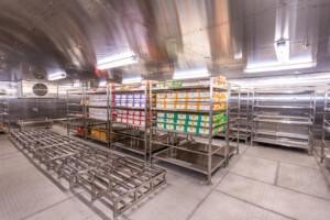 Industrial storage room with stainless steel shelving and organized product boxes – clean, well-lit environment for commercial or marine supply management.