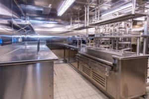 Commercial kitchen with stainless steel countertops, sinks, and storage – clean and well-lit environment for professional food preparation and marine catering.