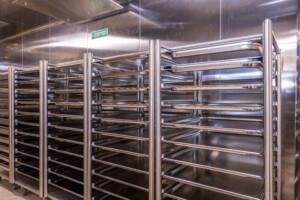 Industrial kitchen or storage area with stainless steel tray racks – clean, sterile environment for commercial or marine food service operations.