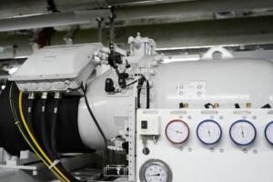 ALMACO industrial machinery unit with pressure gauges and control panel, designed for marine and offshore mechanical systems. Features color-coded gauges, cable management, and robust engineering for shipboard environments.