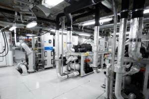ALMACO industrial mechanical room with insulated piping, control units, and electrical panels. Engineered for marine and offshore environments with efficient layout and integrated systems.