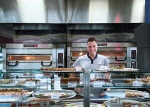 PizzaMaster marine ovens and modular food service counter with assorted pizzas and salads in a cruise ship galley by ALMACO