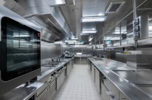 Modern industrial galley kitchen with stainless steel appliances and workstations – ALMACO marine foodservice and catering equipment