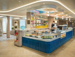 Modern marine café with pastry displays, glass domes, and colorful ceiling art – ALMACO modular hospitality and foodservice design