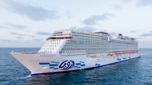 Large cruise ship with multiple decks and balconies sailing on calm ocean waters, featuring ALMACO’s modular marine accommodation and turnkey outfitting solutions.