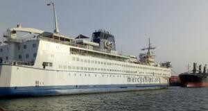 Docked hospital ship with multiple decks and ‘mercyships.org’ branding, representing ALMACO’s marine turnkey solutions for healthcare and accommodation at sea.